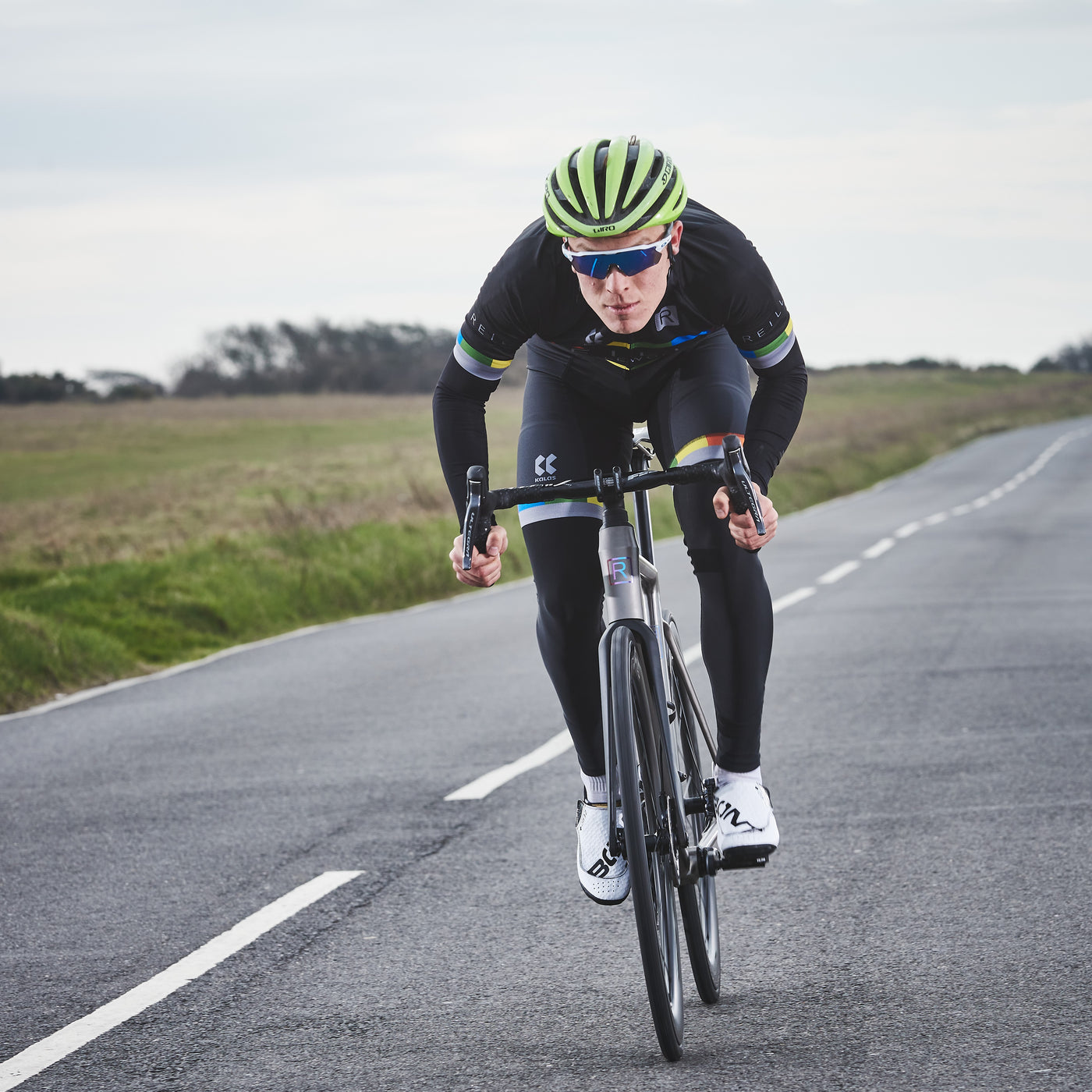 head on shot of road rider on titanium road bike as he cycles on a deserted road. 