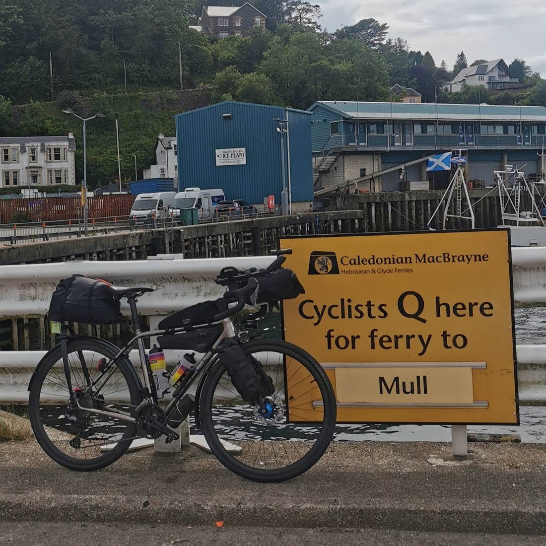 Bike leaning against a sign saying Cyclist Q for ferry to Mull.