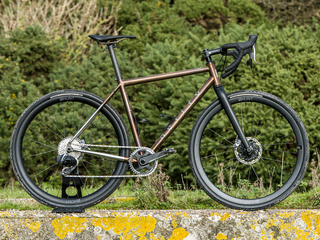 An adventure bike with painted brown frameset on a wall.